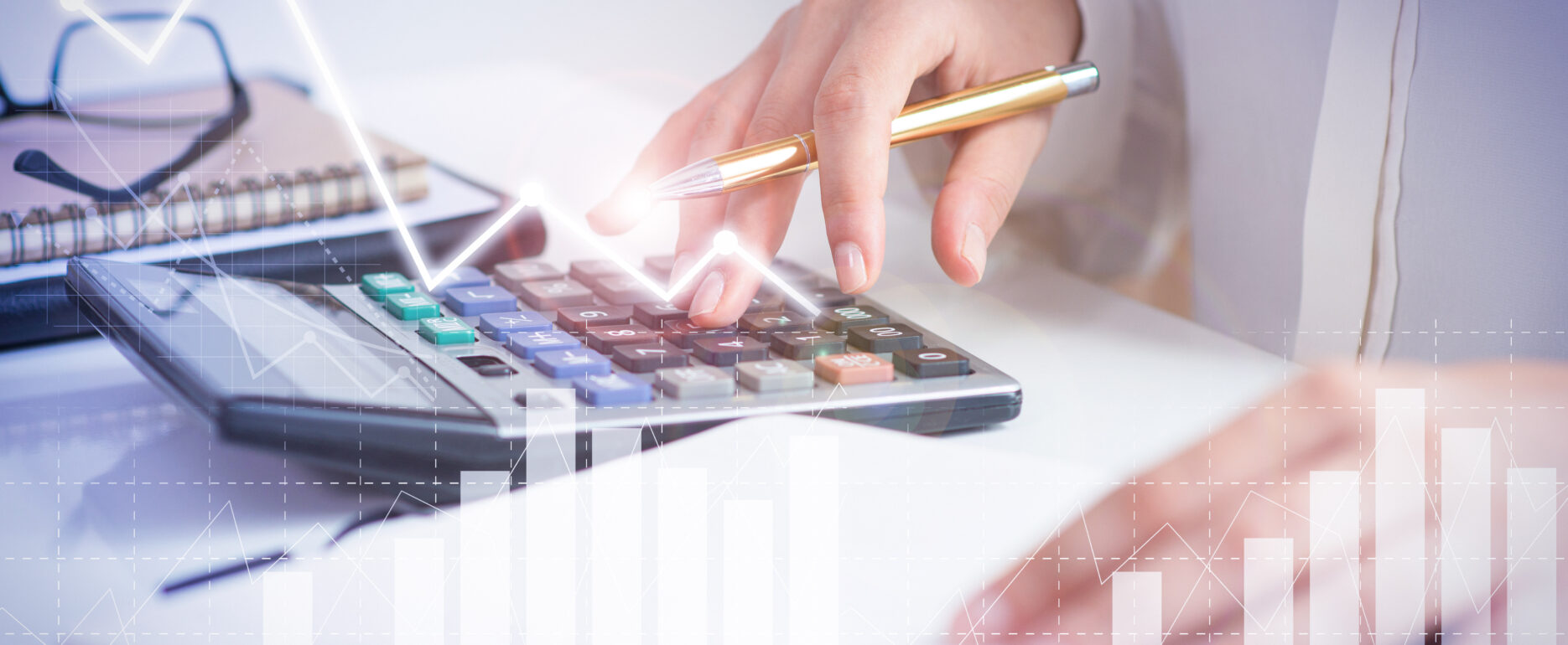 Accountant calculating profit with financial analysis graphs. Notebook, glasses and calculator lying on desk. Accountancy concept. Cropped view.