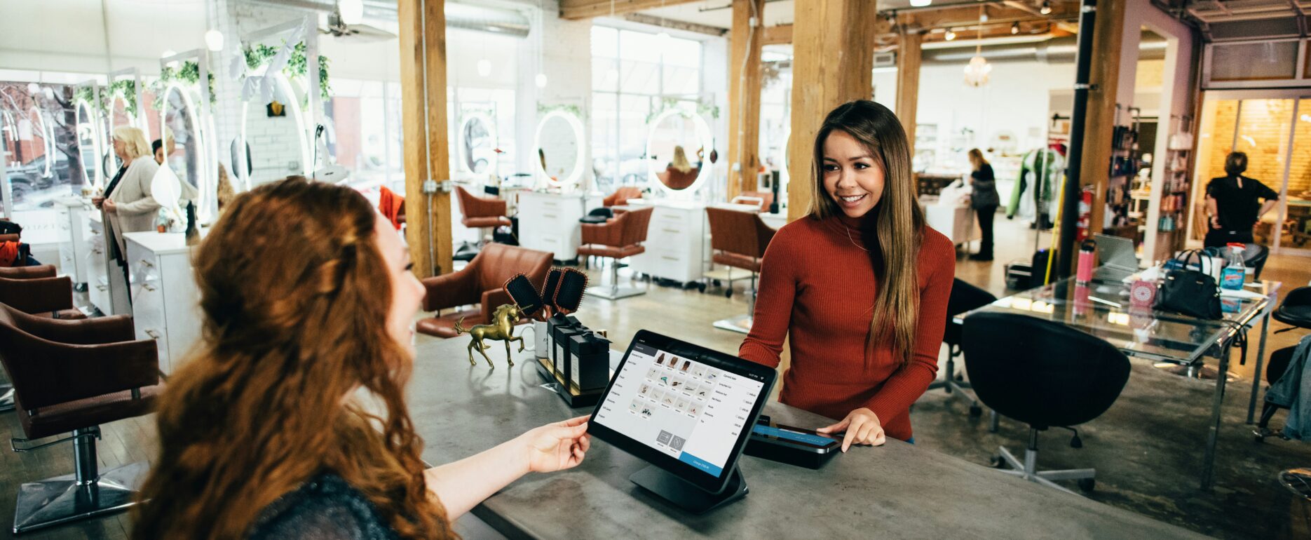 two women talking in front of a laptop