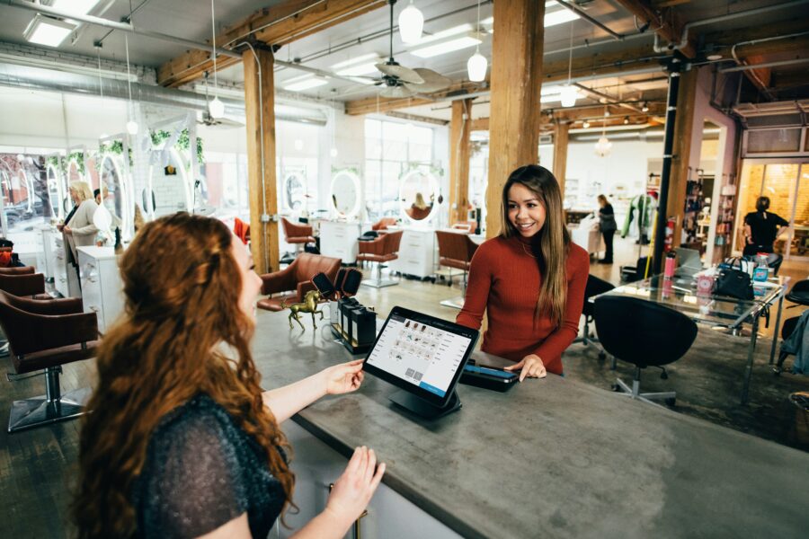 two women talking in front of a laptop