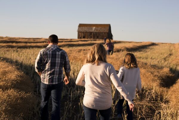 A multiβgeneration farming family standing together, highlighting succession planning and the use of trusts to protect agricultural land for future heirs.