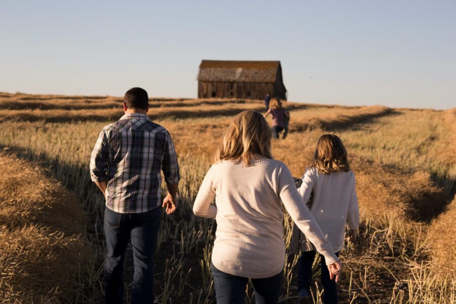 A multi‑generation farming family standing together, highlighting succession planning and the use of trusts to protect agricultural land for future heirs.