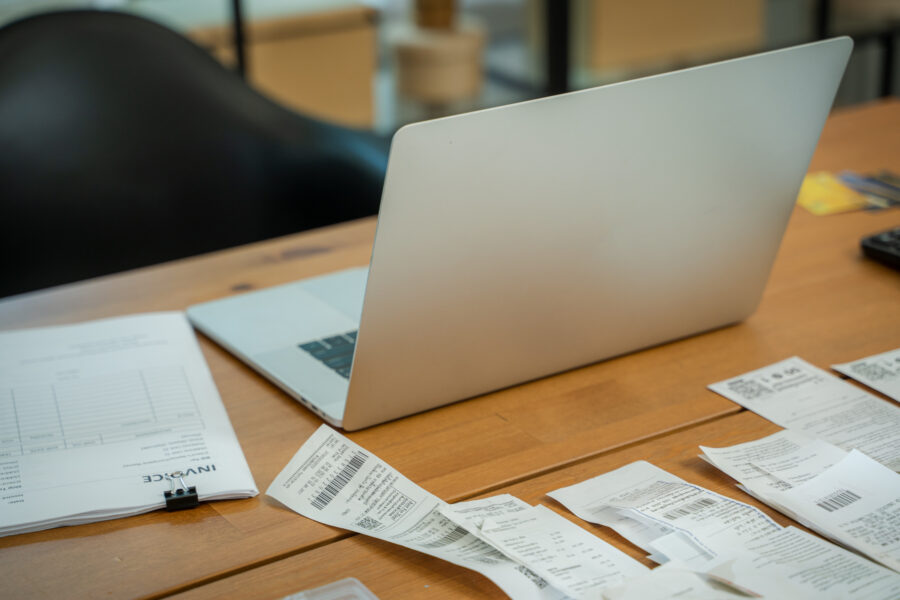 Paper documents and bills for paying online and computer on table in home office,Paper correspondence for managing budget or expenses,Finance concept.
